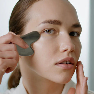 Woman applying a skincare product with a applicator tool.