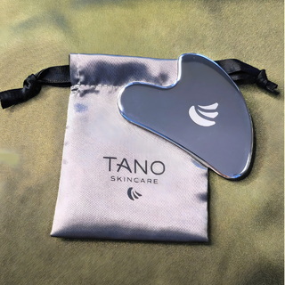 TANO skincare tool with branded pouch on a textured surface